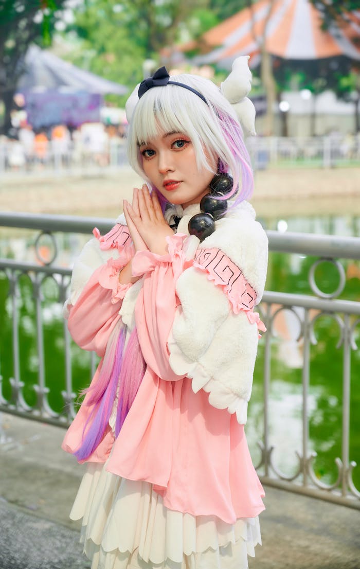 gallery-02 Charming cosplay portrait of a woman in a detailed pink costume with a serene background.