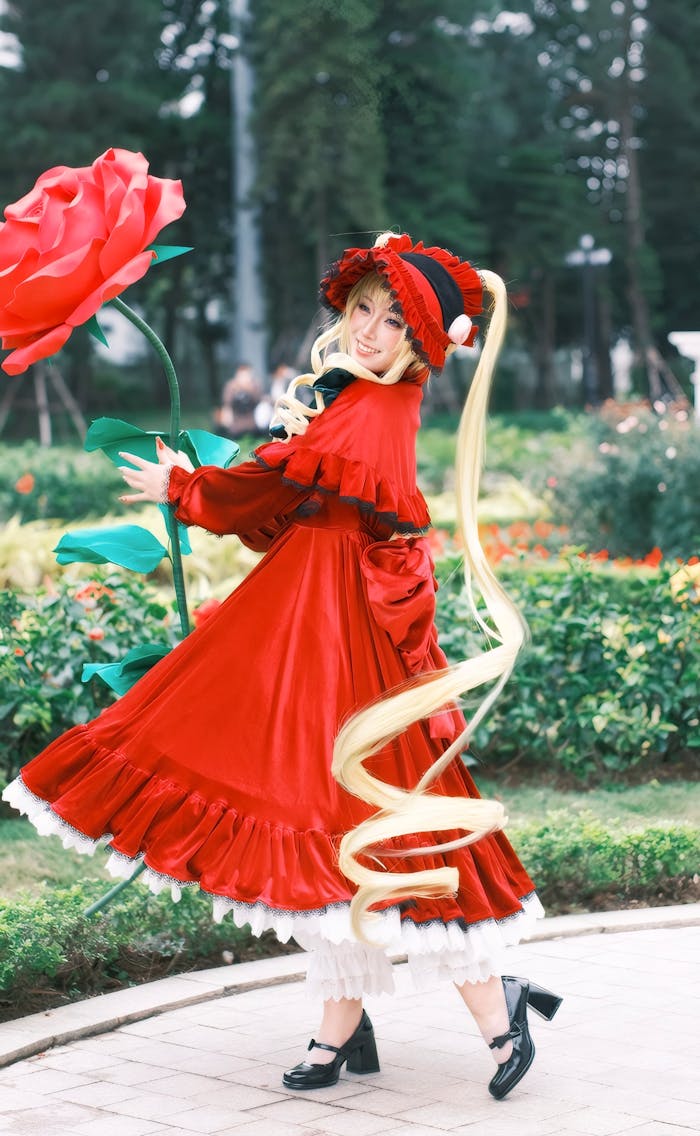 services-02 Cosplay character in vivid red costume in garden setting, holding a giant rose.
