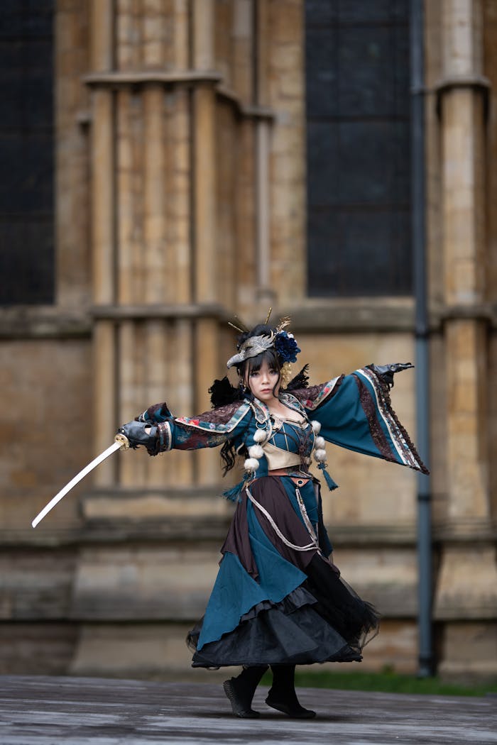 cta-02 Woman in elaborate costume poses with sword against historic building.